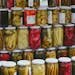 Vibrant display of pickled vegetables in jars at a traditional Turkish market.